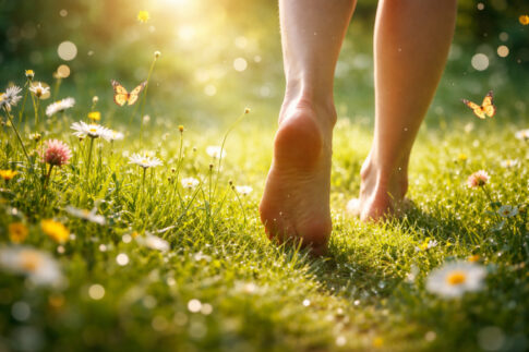草の上を裸足で歩く足（感覚を取り戻すイメージ）