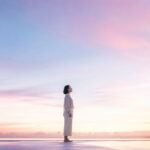 淡いグラデーションの空の下で静かに立つ人物の姿。比べる自分を責めず、自分の軸を取り戻した静かな強さを表す画像