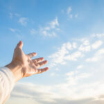 空に向かって開いた手が、手放すことを表すイメージ