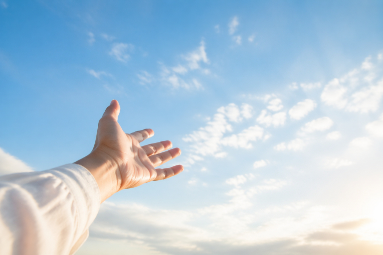 空に向かって開いた手が、手放すことを表すイメージ