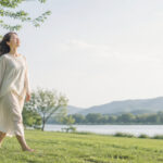 自然の中を歩く女性の姿。五感を通して思考から感覚へ戻ることを表すイメージ。