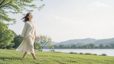 自然の中を歩く女性の姿。五感を通して思考から感覚へ戻ることを表すイメージ。